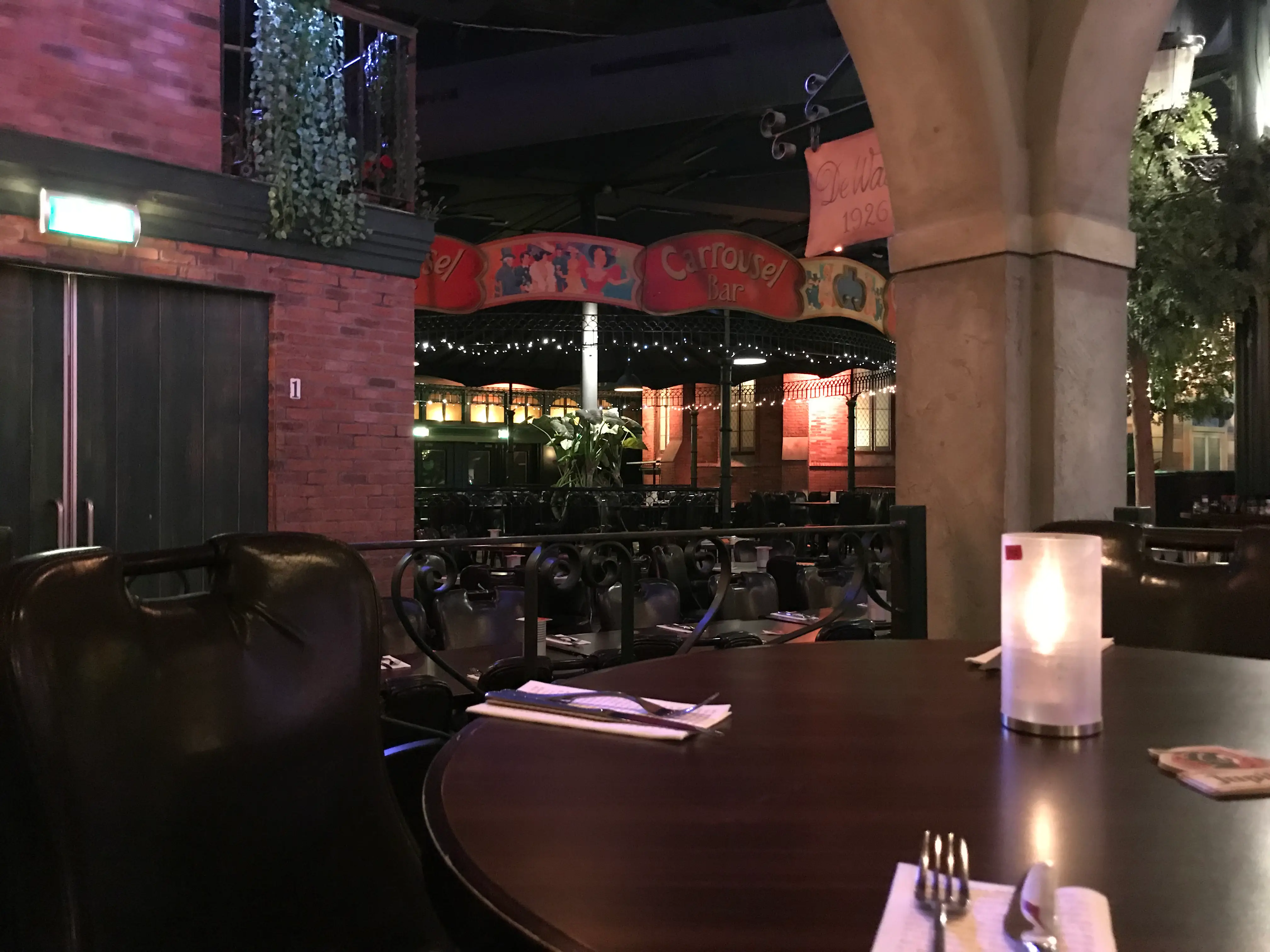 Gedekte tafel met kaarslicht en uitzicht op de sfeervolle Carrousel Bar