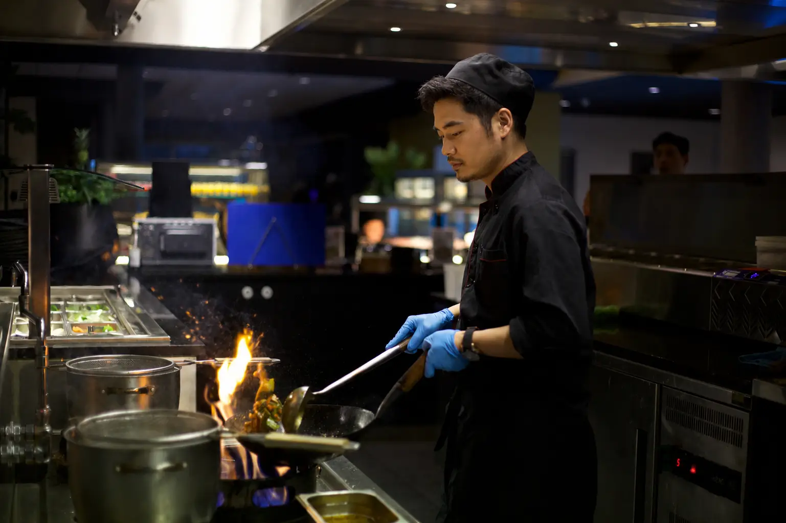 Chef bereidt gerecht live aan de wok met open vlam